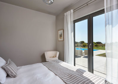 Villa-Piano-bedroom-double-bed-view-pool-arm-chair